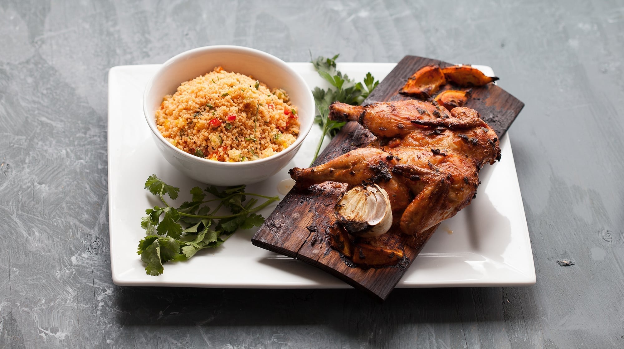 Red Oak Planked Harissa Spatchcocked Game Hen with Cumin Couscous Salad